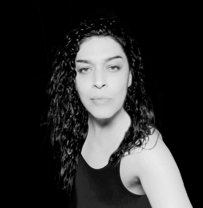 A grayscale portrait of a trans woman looking into the camera