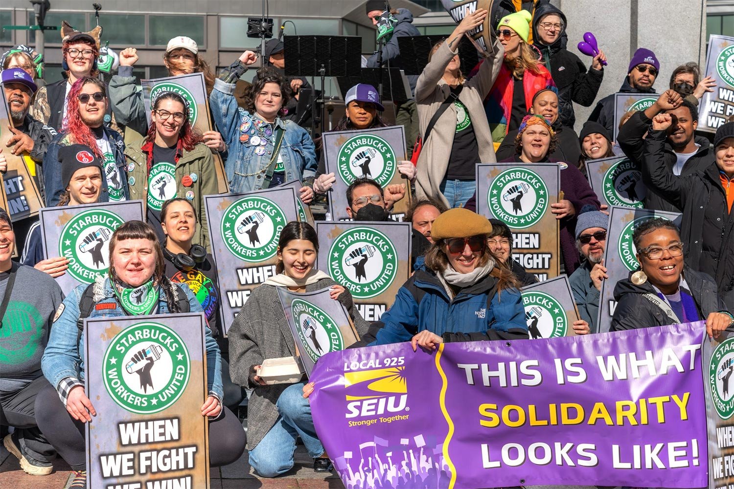 group of Starbucks workers holding signs and banners for the SEIU union